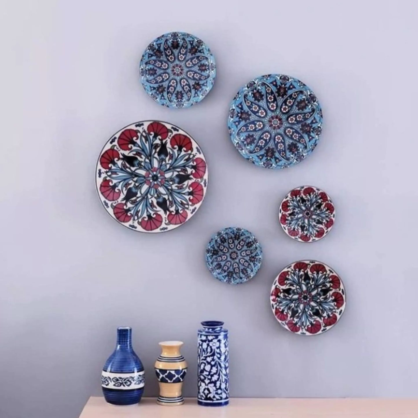 Decorative ceramic plates with intricate patterns on a light gray wall.
