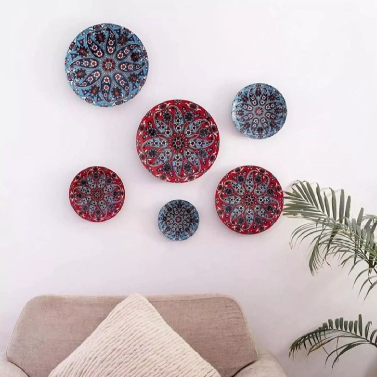 Decorative plates with mandala patterns on a white wall above a sofa.