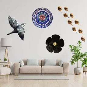 Wall decor products like wall plate, floral plate, flying bird sculpture, adorning a white wall of a living room
