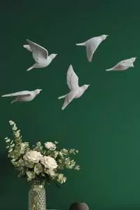 Decorative wall art of white doves against a green background