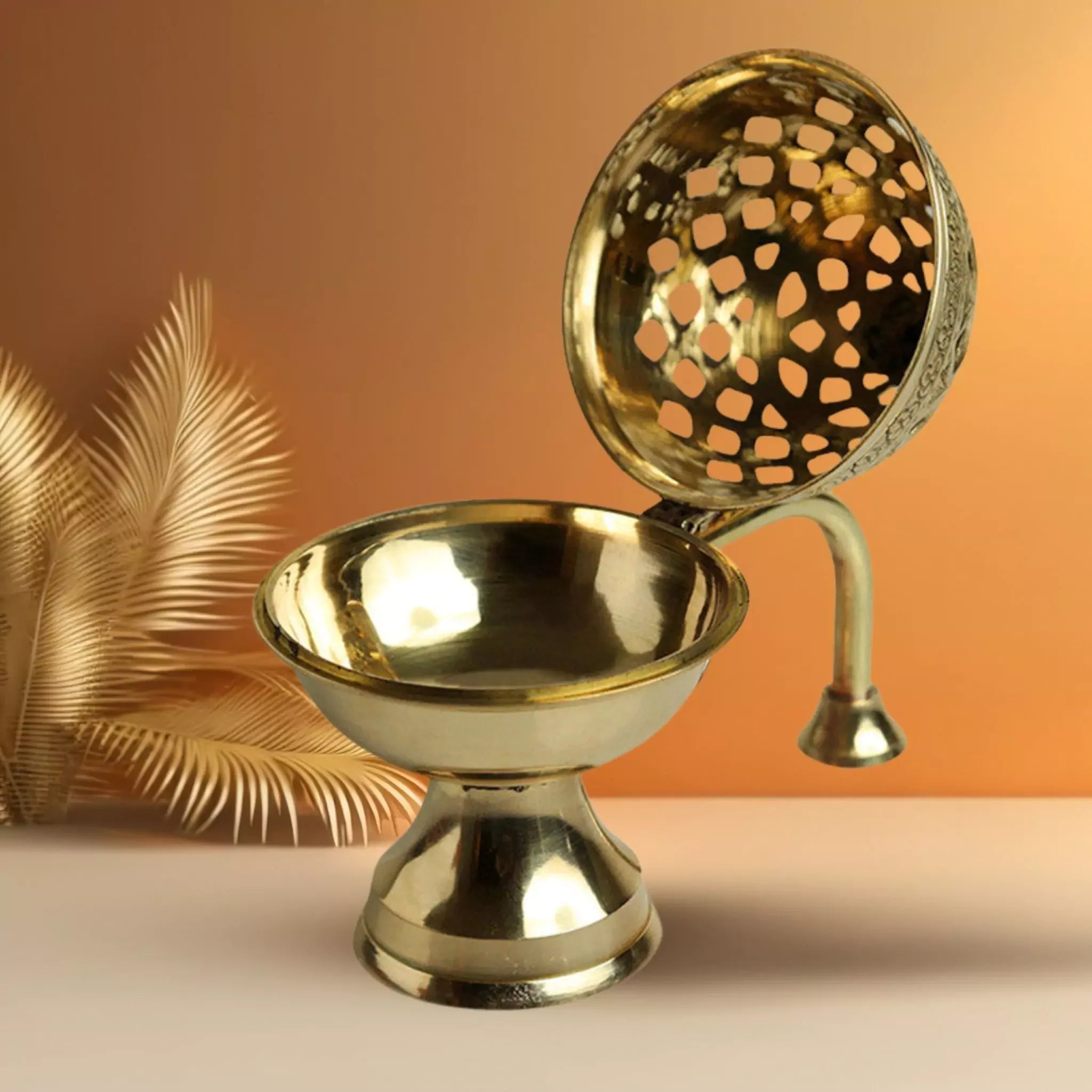 Brass oil lamp with decorative design on an orange background