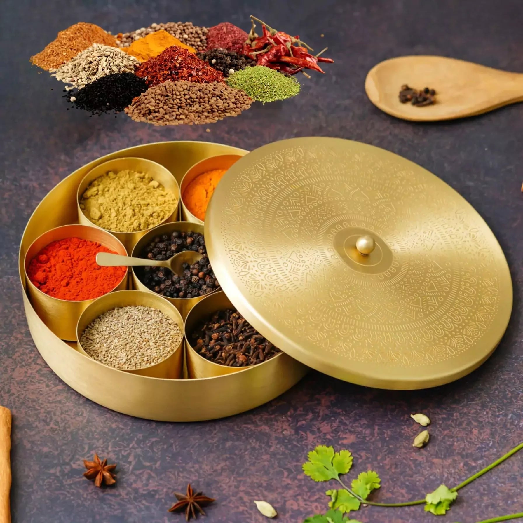 Gold spice container with various spices on a dark surface