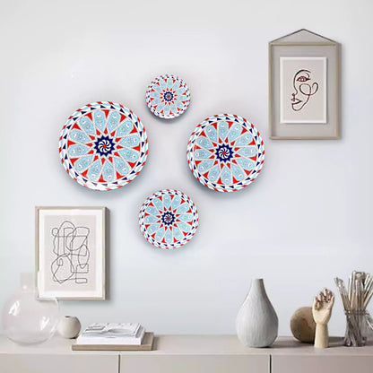 Decorative plates with geometric patterns on a wall with framed art and vases.